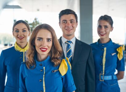 Handsome steward and female flight attendants looking forward