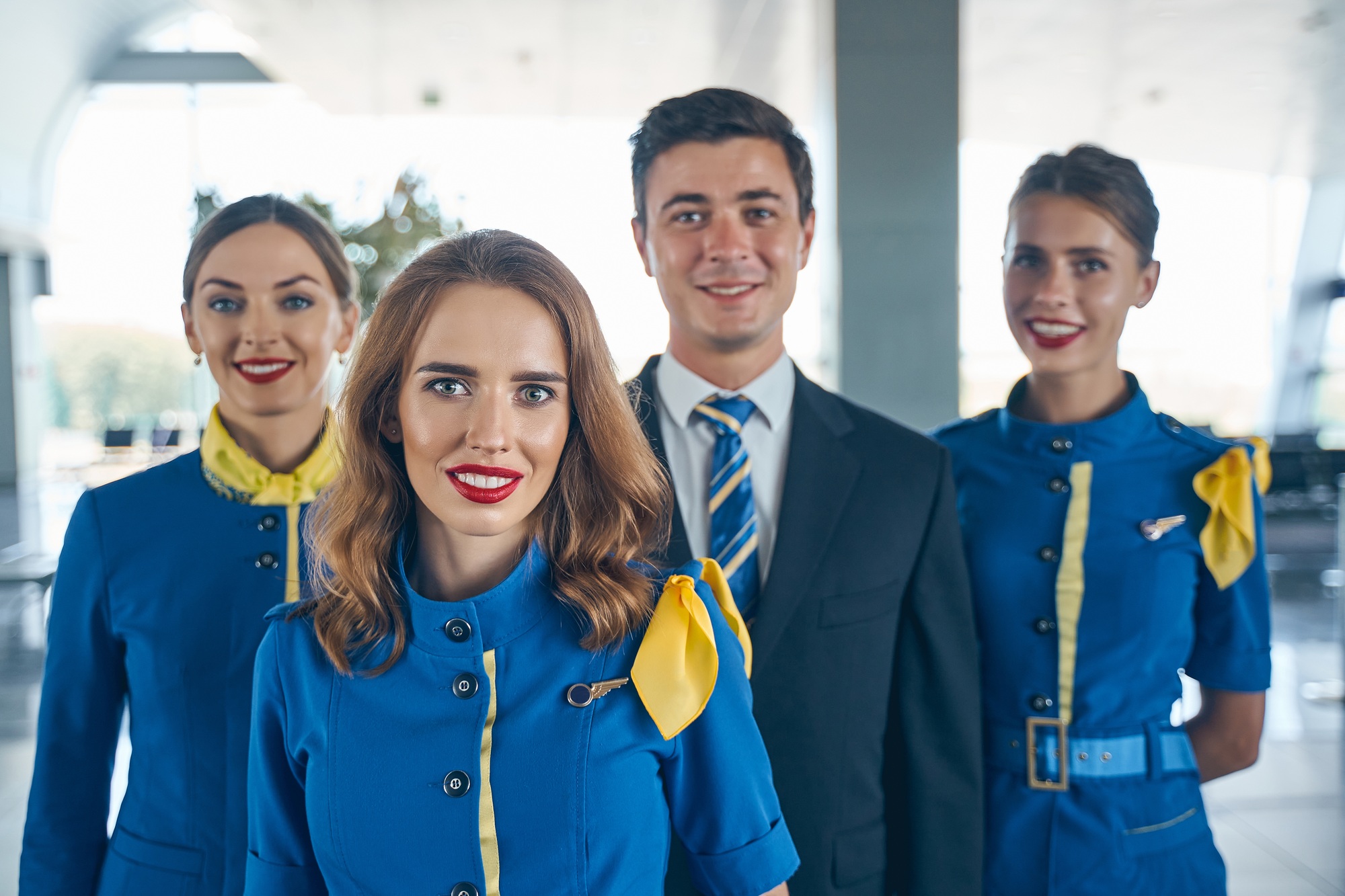 Handsome steward and female flight attendants looking forward
