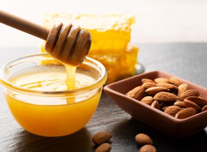 Slate tray with honey almonds and honeycomb on kitchen table