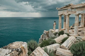 Ruines d'un temple grec antique sur des falaises rocheuses dominant une mer Égée turquoise, évoquant les dieux grecs de la mer