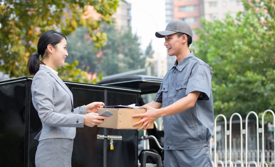 Young woman getting a package from delivery person
